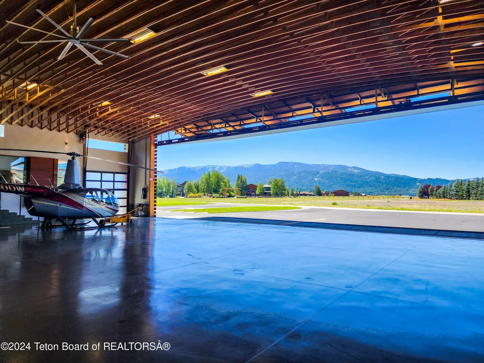 Open hangar door with direct taxiway access and mountain views at 872 Alpine Village Loop